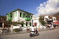 View of a traditional Greeek-Ottoman house with bay window at the town center with a motorcyclist in the foreground, Kas, Antalya Province, Mediterran...