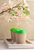 Paper brown cups with a plastic green lid for coffee and tea.