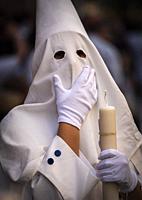 Detail penitent white holding a candle during Holy Week, Spain.