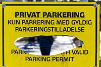 Copenhagen, Denmark A sign sayng no parking in Danish and a large hole in the sign.