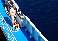 Agiokampos, Evia island, Greece - August 15, 2023: Worker on ferryboat tying rope at Evia island in Greece.