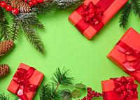 Christmas decor, gifts wrapped in red paper on a green background, top view.