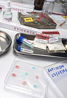 Police scientist examines seizures of adulterated fentanyl in crime lab, Conceptual Image.