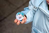 Childhood Wonder: Tiny hands cradle a Christmas snow globe, capturing the enchantment of Santa Claus amid swirling snow inside.