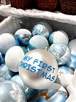 Cherished Debut: A 'My First Christmas' bauble gleams amid a sea of enchanting blue holiday ornaments, capturing the essence of festive beginnings.