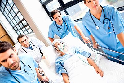 Medical team pushing patient on trolley-stock-photo
