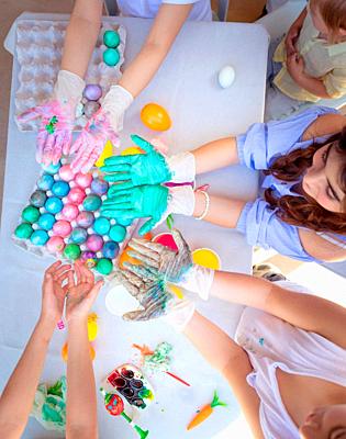 Easter party, schoolkids painting eggs, the traditional food of Easter, children's hands are stained with multicolored paint, festive handmade decorations, holiday fun. Flat lay.-stock-photo
