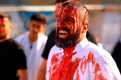 30 August 2020, Iraq, Baghdad: A Shiite Muslims man with blood on his head after hitting himself with a sword, takes part in a ritual ceremony on the day of Ashura in Kadhimiya neighbourhood. Yom Ashura is the tenth day of Muharram, the first month in the Islamic calendar, which marks the day that Husayn ibn Ali, the grandson of the Islamic prophet Muhammad, was killed in the Battle of Karbala. Photo: Ameer Al Mohammedaw/dpa - ATTENTION: graphic content. - Baghdad/Iraq-stock-photo