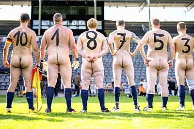 06 September 2020, North Rhine-Westphalia, Wuppertal: Naked footballers from Germany stand side by side with numbers painted on their backs in front of the game in the stadium at the zoo. In protest against what they see as the increasing commercialisation of professional football, two teams competed naked against each other. The organizer of the naked football is the artist Starczewski, who wants to appoint each participant as an official naked player by certificate. Photo: Marcel Kusch/dpa. - Wuppertal/North Rhine-Westphalia/Germany-stock-photo