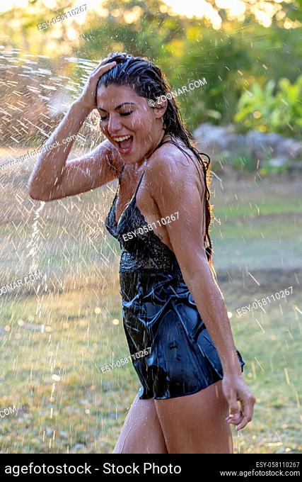 A beautiful hispanic brunette model enjoying a hot summer day while running through water