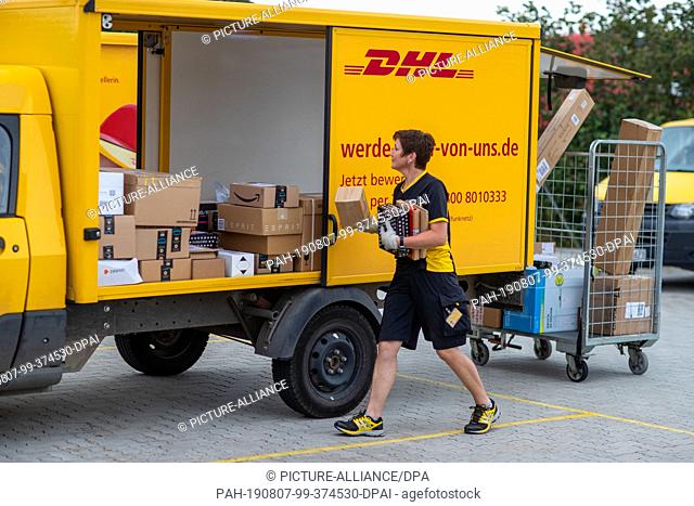 07 August 2019, Mecklenburg-Western Pomerania, Wittenburg: Parcel carrier Ute Eissing loads the electrically driven transporter ""Streetscooter"" at Deutsche...