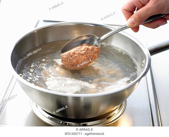 Making liver dumplings: putting dumpling mixture into water