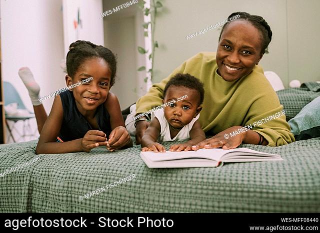 Smiling mother with son and daughter in bedroom