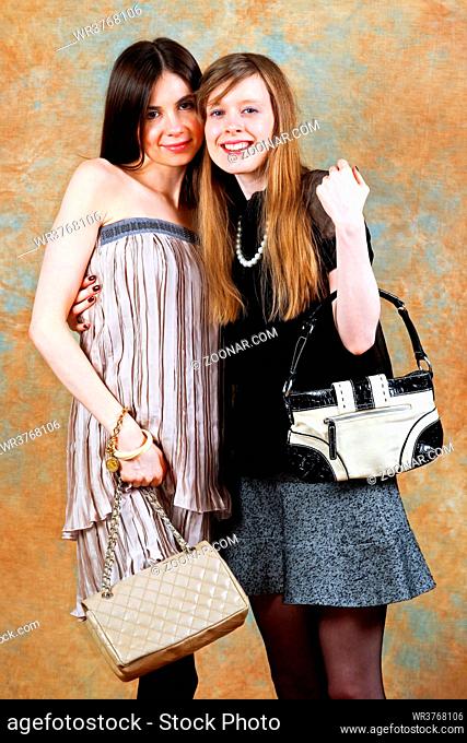 Two girlfriends in fashion clothing with purse