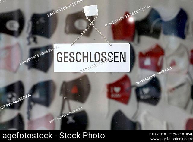 09 November 2020, North Rhine-Westphalia, Cologne: A sign ""Closed"" hangs in the door of a shop for fabric masks. The government wants to lower the corona...