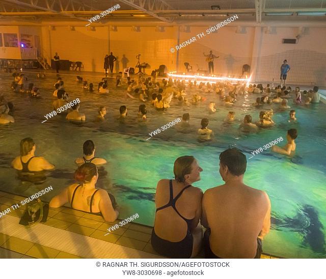 People celebrating the Winter Lights Festival at a neigborhood pool near Reykjavik, Iceland