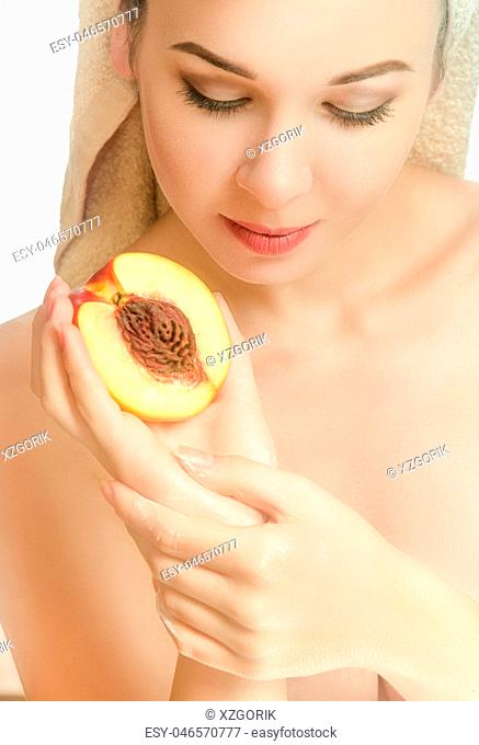 Woman with half a peach and a towel on her head