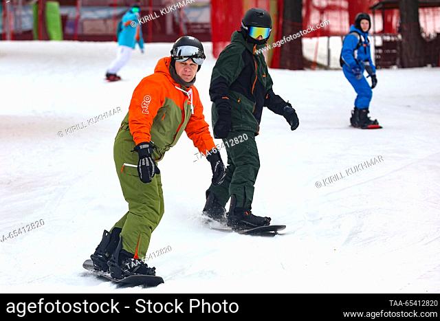 RUSSIA, ALTAI REPUBLIC - DECEMBER 2, 2023: Snowboarders at the Manzherok year-round ski resort located at the foot of Mount Malaya Sinyukha