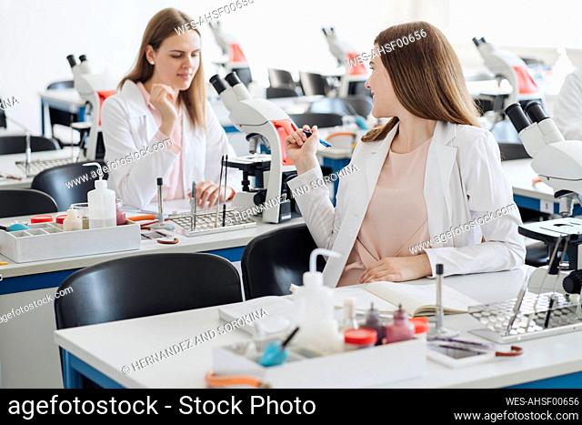 Young female researchers talking in science class