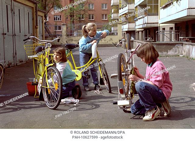 Mona, Ina and Katja (l-r) clean their bicycles after the winter on the 25th of April in 1988. - /Germany