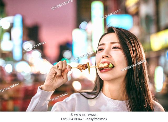 Asian young woman enjoy street food in Night Market