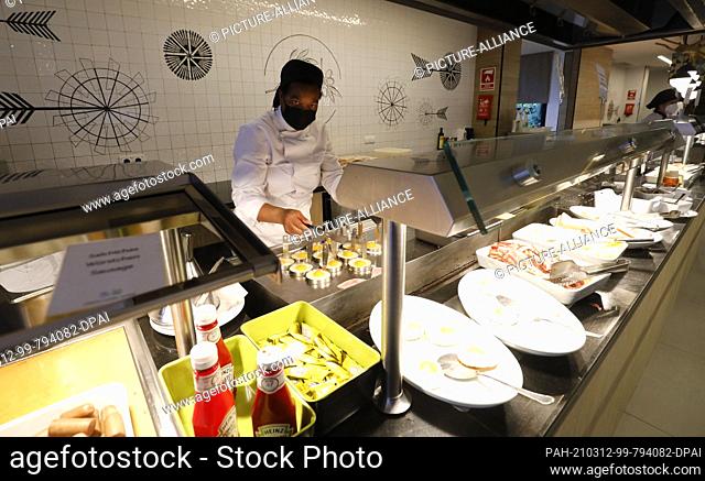12 March 2021, Spain, Palma: A staff member prepares eggs for breakfast on the buffet at the Riu Festival Hotel in Palma de Mallorca
