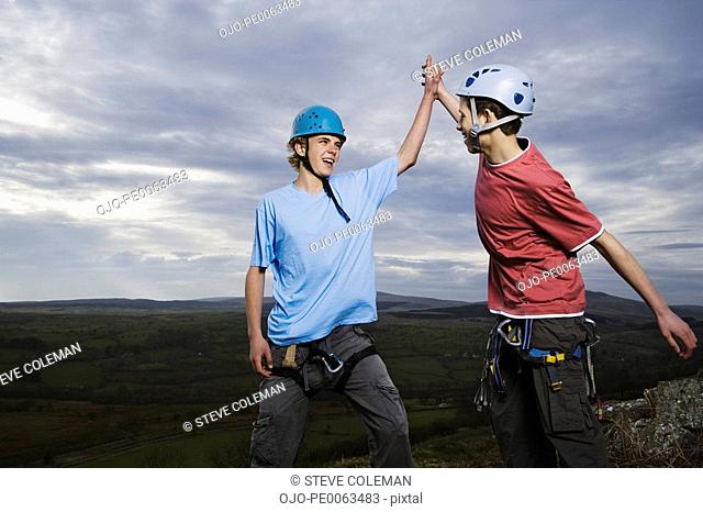 Teenage boys rock climbing