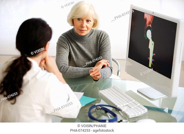 Doctor discussing hip replacement X-ray with a patient