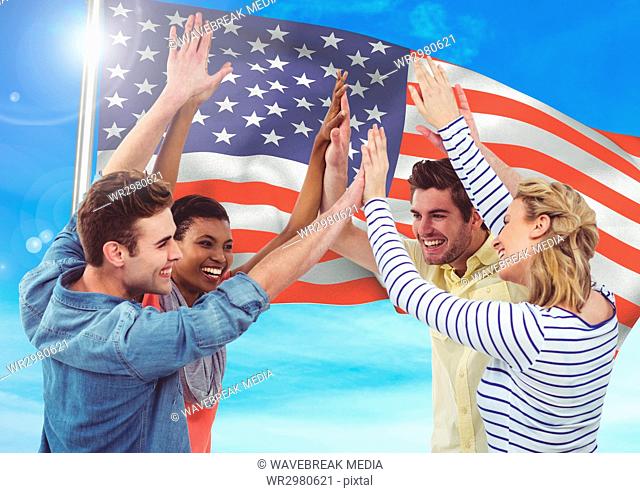 Smiling friends throwing up their hands against fluttering american flag background