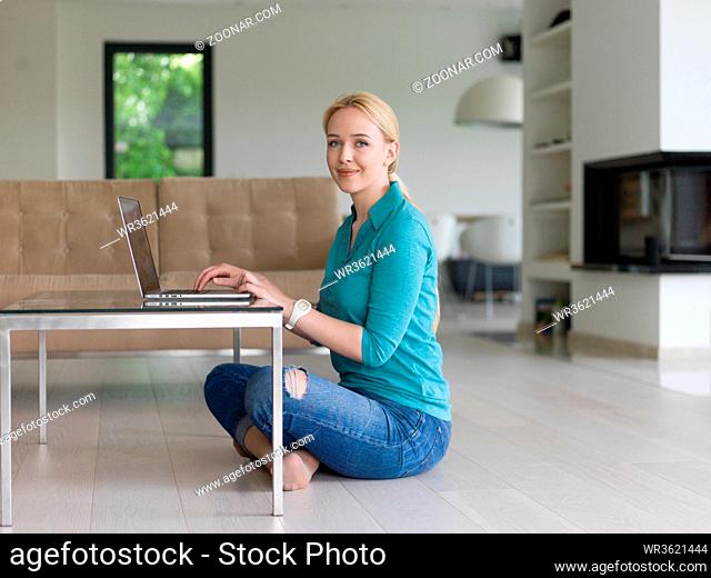 beautiful young women using laptop computer on the floor of her luxury home