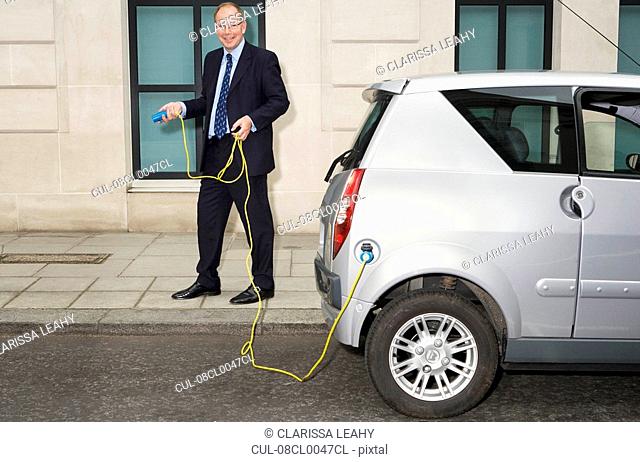 Man holding cable for electric car