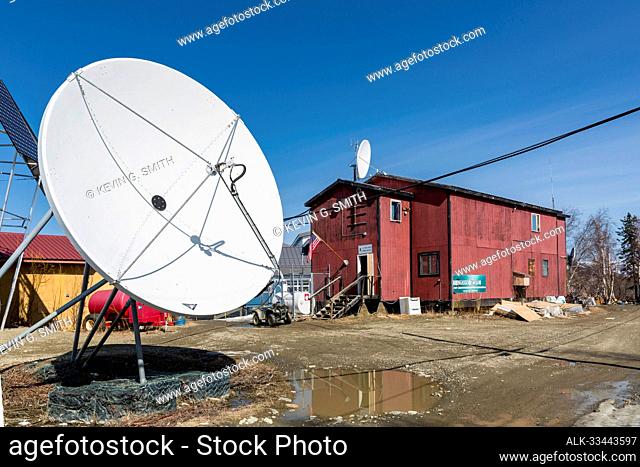 Satelite dish sits outside the post office in the native vilage of Kobuk in springtime, Northwestern Alaska, USA; Kobuk, Alaska, United States of America