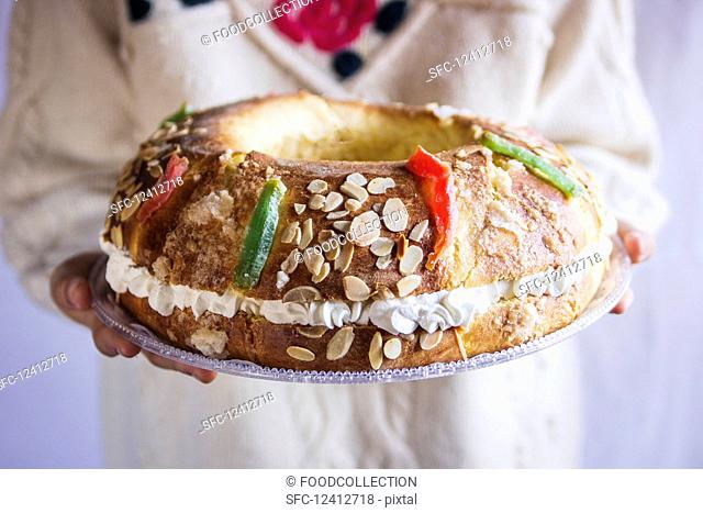 A woman serving Roscon de Reyes (royal cake, Spain) for Christmas
