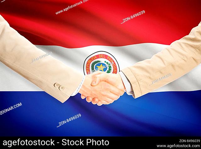 Businessmen shaking hands with flag on background - Paraguay