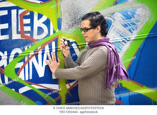 A blind student touches a bus before taking a picture of it during a photography workshop for the blind and visually impaired