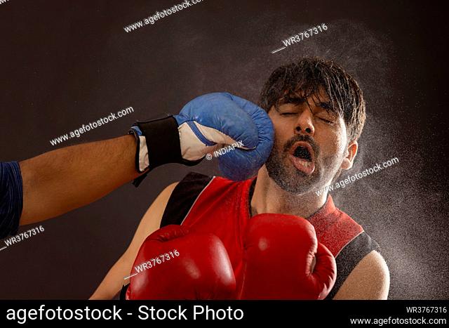 A BOXER BEING PUNCHED DURING A BOXING MATCH