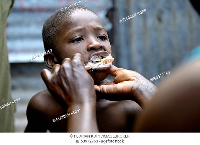 Boy, 7 years, having his teeth brushed, Camp Icare, camp for earthquake refugees, Fort National, Port-au-Prince, Haiti