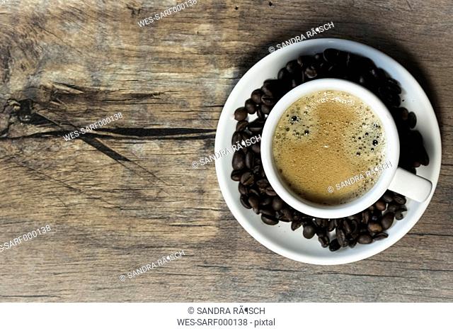 Elevated view of cup of coffee on wooden table