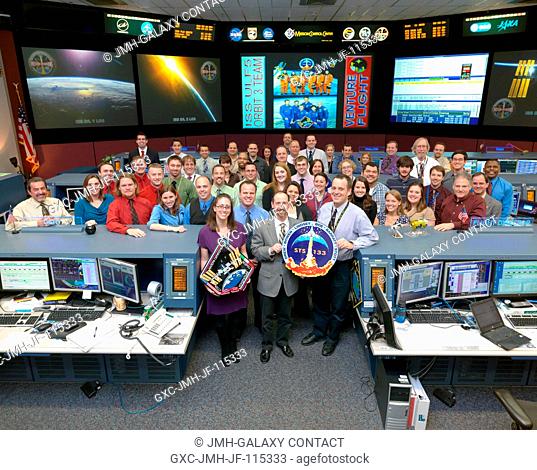 The members of the STS-133ULF5 ISS Orbit 3 flight control team pose for a group portrait in the space station flight control room in the Mission Control Center...