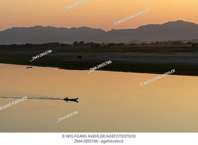 A man in a boat on the Irrawaddy River (Ayeyarwady River) at sunset in Bagan, Myanmar