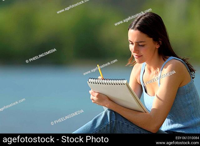 Woman drawing on notebook outdoors