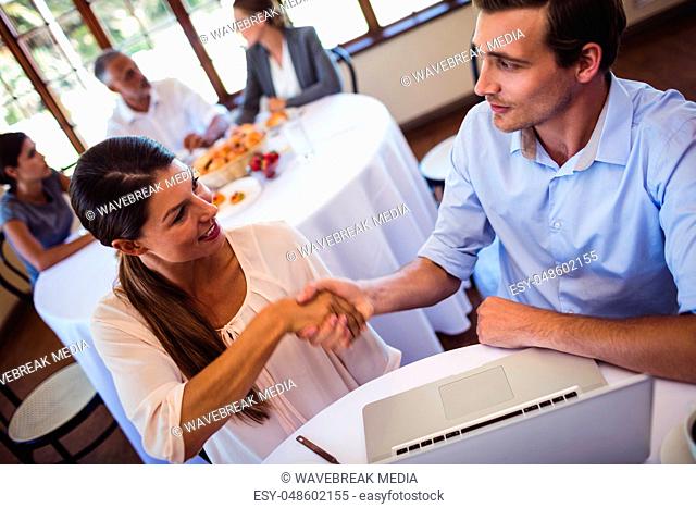 Business people shaking hands in restaurant