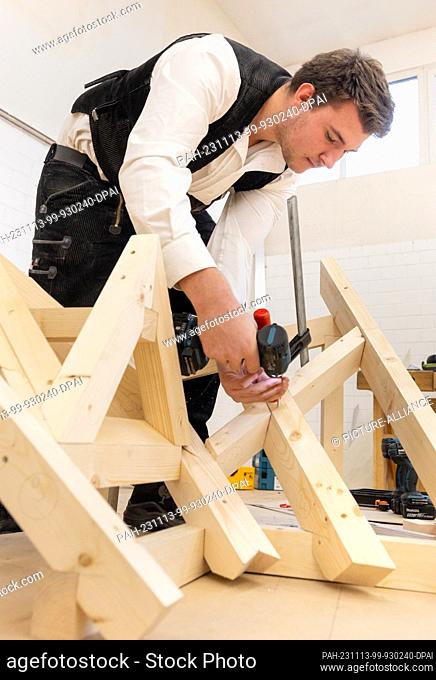 13 November 2023, Thuringia, Erfurt: Carpenter Moritz Benedikt Müller (Berlin) builds a roof truss model at the German Building Trade Championships