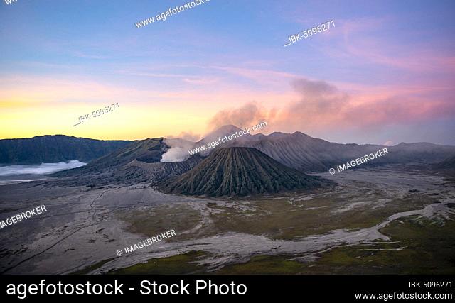 Volcanic landscape at sunrise, smoking volcano Gunung Bromo, with Mt. Batok, Mt. Kursi, Mt. Gunung Semeru, Bromo-Tengger-Semeru National Park, Java, Indonesia