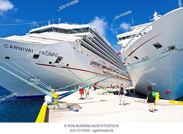 Cruise ship passengers on pier disembarking from Carnival cruise ships Triumph and Ecstasy in Cozumel, Mexico in the Caribbean Sea