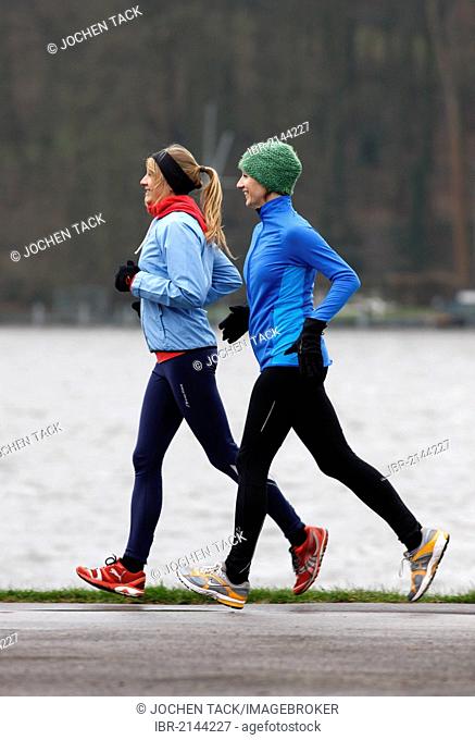Two young women jogging in winter, wearing wind and waterproof performance apparel