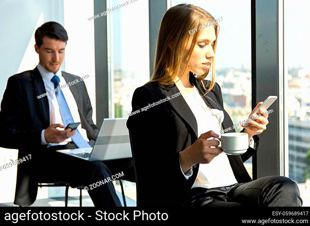 Young workers having break at office and resting near window