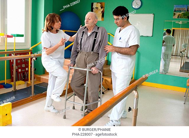 Elderly man in functional reeducation session with a physiotherapist after the break a hip. Residential home for dependent elderly person, Limoges, France