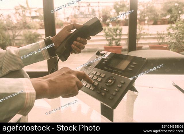 Close up male of hand holding telephone receiver and dialing a telephone number to make a call using Landline phone for Business Talk