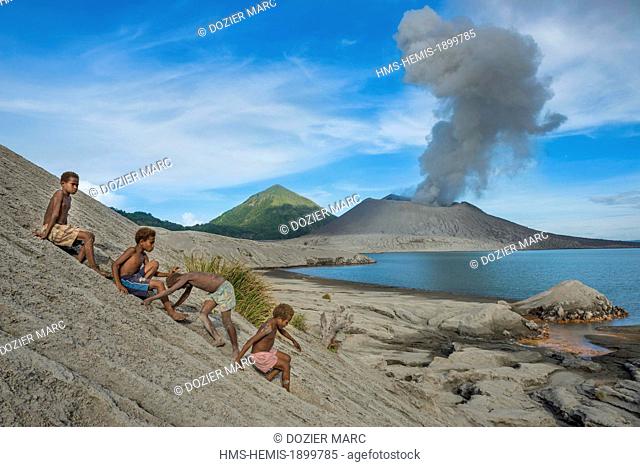 Papua New Guinea, Bismarck Archipelago, Gazelle peninsula, New Britain island, East New Britain province, Rabaul, kids playing in the ashes in front of volcano...